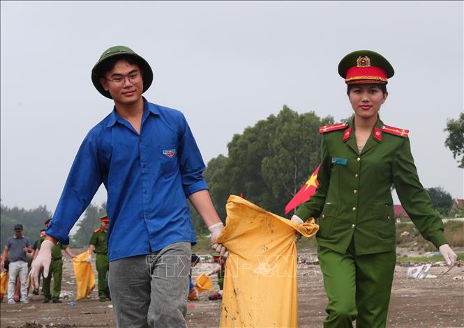 Tuổi trẻ lực lượng Công an xã Văn Hải phối hợp đoàn viên thanh niên tham gia dọn vệ sinh môi trường, làm sạch bãi biển chuẩn bị đón mùa du lịch. Ảnh: Trọng Đức - TTXVN