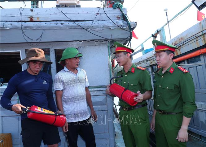 Cán bộ Công an xã Văn Hải, huyện Quỳnh Lưu, tỉnh Nghệ An tuyên truyền kiến thức, kỹ năng phòng cháy, chữa cháy và cứu nạn, cứu hộ cho ngư dân trên tàu cá neo đậu tại cảng Lạch Thơi. Ảnh: Trọng Đức - TTXVN