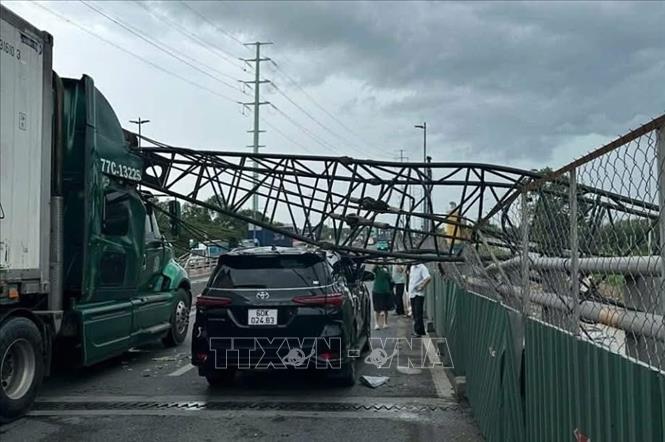 Cần cẩu thi công đè trúng hai xe ô tô trên cầu vượt Mỹ Thủy, thành phố Thủ Đức. Ảnh: TTXVN phát