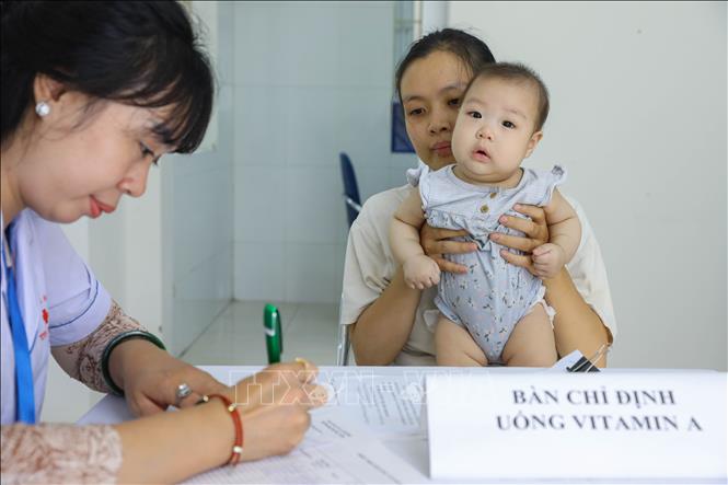 Cán bộ y tế làm thủ tục cho  trẻ trong độ tuổi bổ sung vi chất tại Trạm Y tế phường Ngọc Hà (quận Ba Đình). Ảnh: Lê Đông - TTXVN
