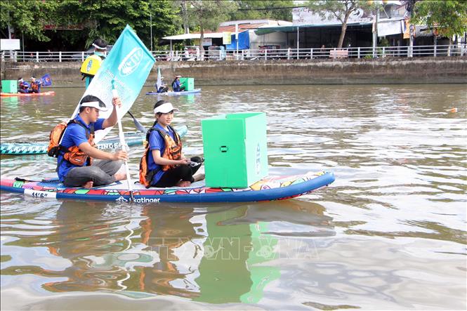 Lực lượng tình nguyện viên được trang bị ván chèo SUP để tham gia dọn dẹp rác ở khu vực chân cầu Rạch Ngỗng 1 (phường Thới Bình, Ninh Kiều). Ảnh: Trung Kiên - TTXVN