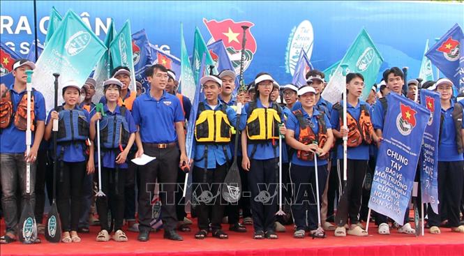 Đoàn viên thanh niên quận Ninh Kiều thể hiện quyết tâm trước khi ra quân dọn rác trên sông. Ảnh: Trung Kiên - TTXVN