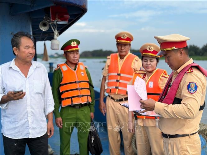 Lực lượng Cảnh sát đường thủy Long An kiểm tra chủ phương tiện vận chuyển khoáng sản trên sông Vàm Cỏ Đông. Ảnh: TTXVN phát