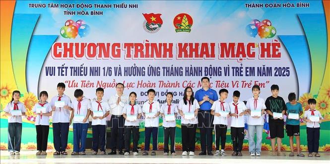 Ban tổ chức Chương trình và lãnh đạo UBND thành phố Hòa Bình tặng quà cho thiếu nhi có hoàn cảnh khó khăn vươn lên trong học tập. Ảnh: Vũ Hà- TTXVN