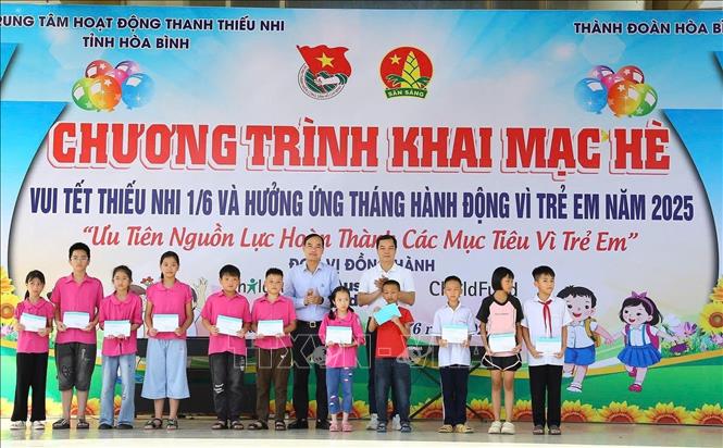 Ban tổ chức Chương trình cùng lãnh đạo UBND thành phố Hòa Bình tặng quà cho thiếu nhi có hoàn cảnh khó khăn vươn lên trong học tập. Ảnh: Vũ Hà- TTXVN