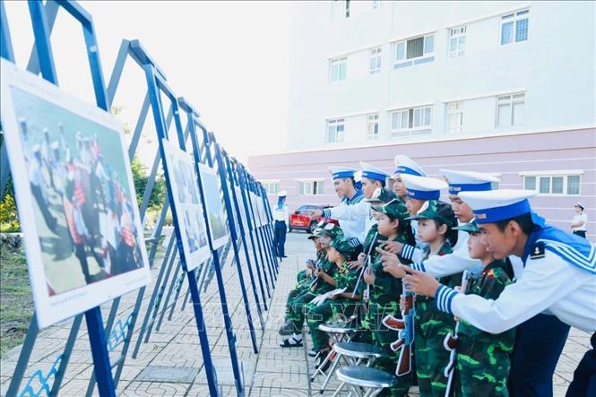 Thiếu nhi cùng lực lượng hải quân Vùng 4 tham quan ảnh trưng bày tại Vùng 4 Hải quân.Ảnh: TTXVN phát
