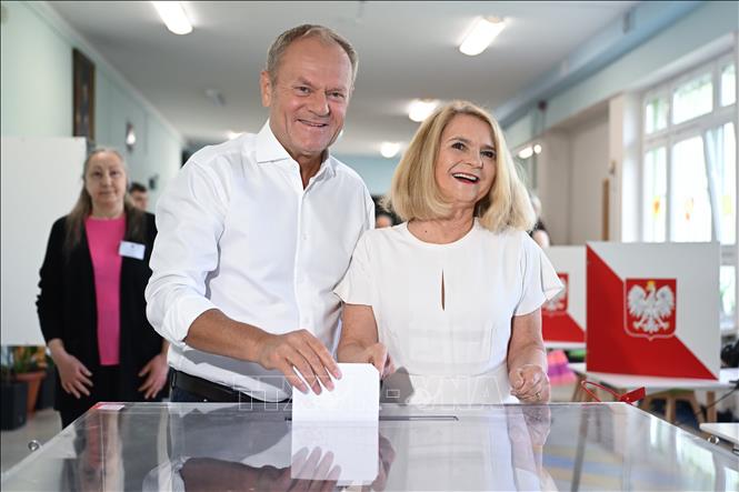 Thủ tướng Ba Lan Donald Tusk (trái) và phu nhân bỏ phiếu bầu Tổng thống vòng hai tại điểm bầu cử ở Sopot, Ba Lan, ngày 1/6/2025. Ảnh: PAP/TTXVN