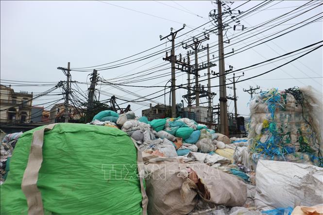 Người dân làng nghề Minh Khai mang rác thải nhựa bày, vứt quây kín cả trạm biến áp điện của thôn. Ảnh: Mạnh Khánh-TTXVN                              