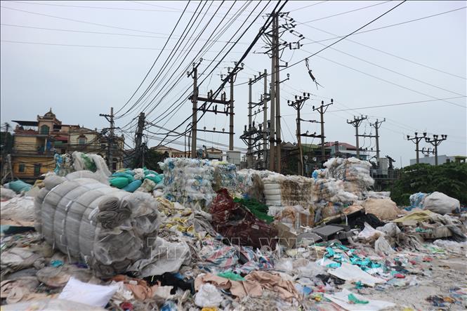 Trạm biến áp điện ở làng nghề Minh Khai bị rác thải nhựa quây kín, tiềm ẩn nguy cơ cháy nổ. Ảnh: Mạnh Khánh-TTXVN                             
