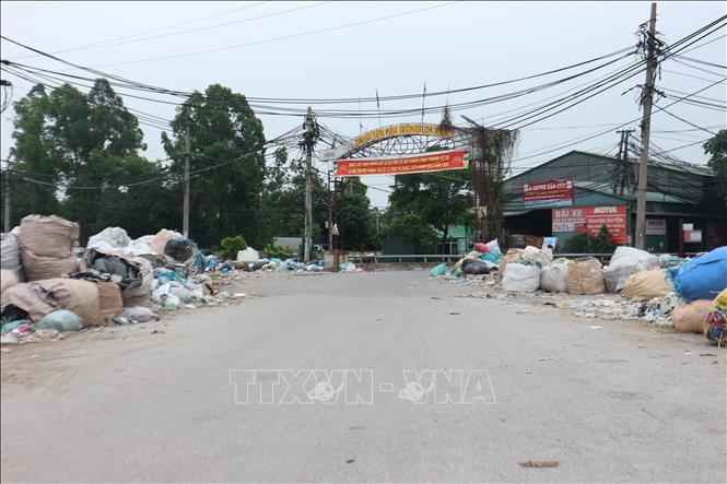  Rác thải nhựa được bày, vứt tràn lan trên đường dẫn vào thôn Minh Khai. Ảnh: Mạnh Khánh-TTXVN                              