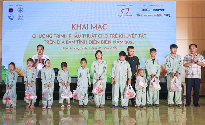 Ban tổ chức trao quà cho trẻ em có hoàn cảnh khó khăn tham gia phẫu thuật khuyết tật tại chương trình.​ Ảnh: Xuân Tư - TTXVN