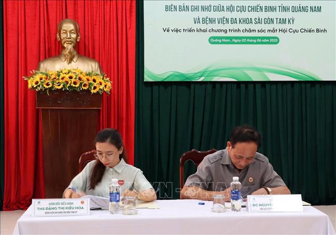 Đại diện Hội cựu chiến bnh tỉnh Quảng Nam và đại diện Bệnh viện đa khoa Sài Gòn Tam Kỳ ký kết hợp tác. Ảnh: Trịnh Bang Nhiệm - TTXVN