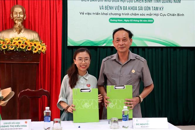 Đại diện Hội cựu chiến binh tỉnh Quảng Nam và đại diện Bệnh viện đa khoa Sài Gòn Tam Kỳ trao bản ký kết. Ảnh: Trịnh Bang Nhiệm - TTXVN