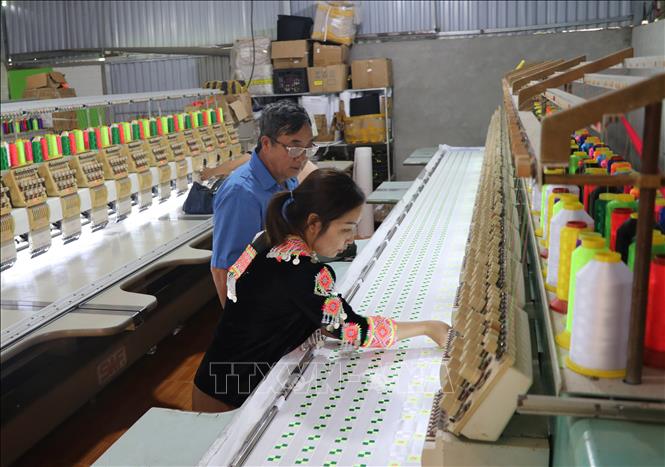 Ông Lầu Văn Thào, Bí thư Chi bộ thôn Nà Tang, xã Hùng Lợi, huyện Yên Sơn thăm một xưởng dệt trong thôn. Ảnh: Hoàng Hải - TTXVN
