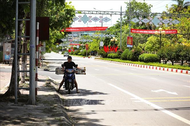Người dân dừng xe tránh nắng dưới bóng cây chờ đèn đỏ trên Đại lộ Thịnh Lang, thành phố Hòa Bình. Ảnh: Trọng Đạt - TTXVN