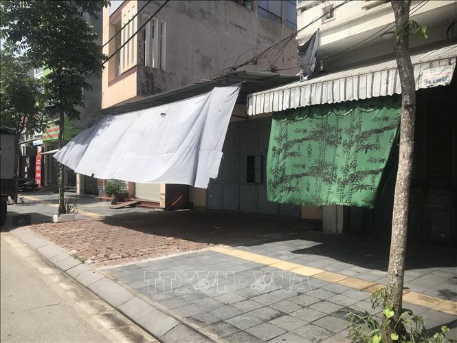 Nhiều gia đình phải căng vải trước cửa nhà để tránh nắng nóng. Ảnh: Tiến Vĩnh - TTXVN