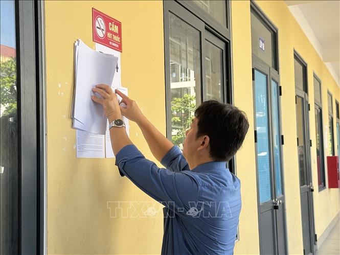 Cán bộ coi thi kiểm tra phòng thi tại Hội đồng thi THCS Nguyễn Du (thành phố Hà Tĩnh). Ảnh: Hoàng Ngà - TTXVN