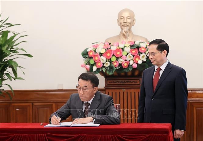 Quyền Trưởng Ban Đối ngoại Trung ương Đảng Nhân dân Cách mạng Lào Bounlua Phandanouvong ghi sổ lưu bút. Ảnh: An Đăng - TTXVN