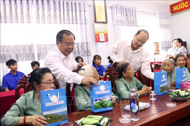 Bí thư Tỉnh ủy Cà Mau Nguyễn Hồ Hải (phải) và Phó Chủ tịch Ủy ban nhân dân tỉnh Cà Mau Nguyễn Minh Luân tặng quà cho người già tại Trung tâm Bảo trợ xã hội tỉnh. Ảnh: Kim Há - TTXVN 