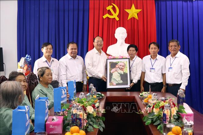 Lãnh đạo tỉnh Cà Mau trao tặng ảnh chân dung Chủ tịch Hồ Chi Minh cho Ban Giám đốc Trung tâm Bảo trợ xã hội tỉnh. Ảnh: Kim Há - TTXVN 