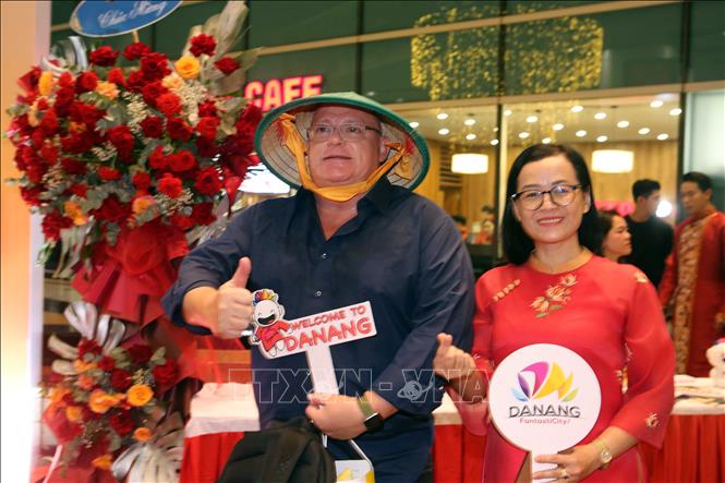 Hành khách quốc tế thích thú với những chiếc nón lá Việt Nam được tặng tại chương trình khai trương đường bay mới của Hãng hàng không Emirates. Ảnh: Trần Lê Lâm - TTXVN 