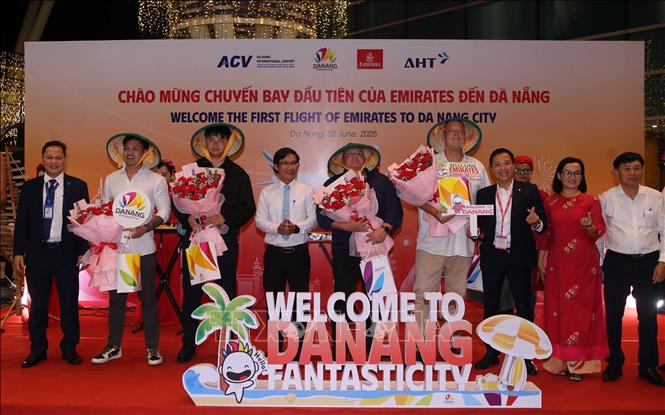 Ban Tổ chức tặng hoa và quà chúc mừng những hành khách đầu tiên đến Đà Nẵng trên đường bay của Hãng hàng không Emirates. Ảnh: Trần Lê Lâm - TTXVN 