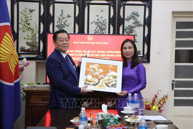 Trưởng Ban Tuyên giáo và Dân vận Trung ương Nguyễn Trọng Nghĩa thay mặt đoàn đại biểu tặng quà cho Đại sứ Trịnh Thị Tâm. Ảnh: Ngọc Thúy - PV TTXVN tại Nam Á