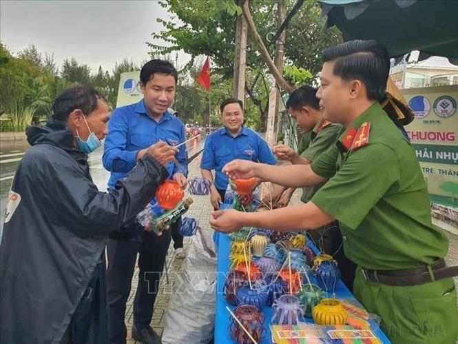 Người dân đem các loại chai nhựa, lon nhôm, pin cũ đã qua sử dụng đế đổi đèn Trung Thu trong chương trình tuyên truyền kêu gọi mọi người phân loại rác thải nhựa để bảo vệ môi trường, góp phần xây dựng Bến Tre xanh. Ảnh: TTXVN phát