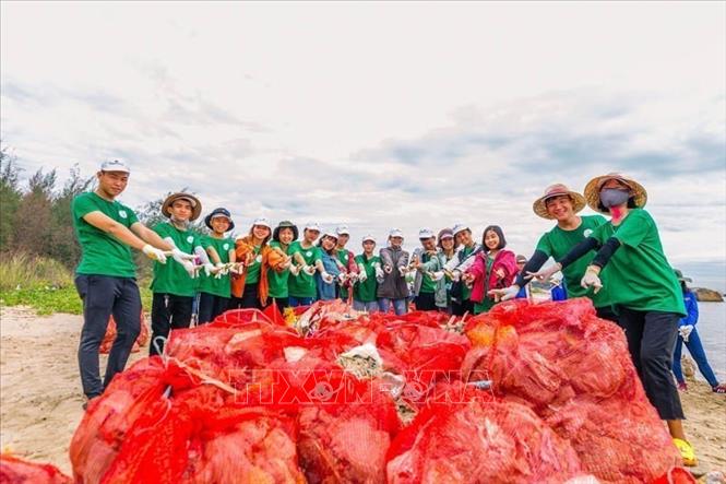 Nhóm dự án Tử tế với Sa Cần thu gom rác thải nhựa ở cửa biển Sa Cần, xã Bình Thạnh, Bình Sơn, Quảng Ngãi. Ảnh: TTXVN phát