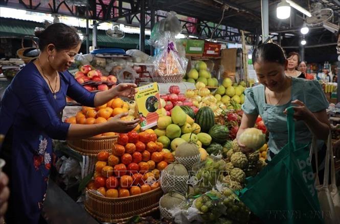 Người dân thành phố Huế sử dụng túi vải mua sắm tại chợ Đông Ba, nhằm nâng cao nhận thức, tạo thói quen hạn chế sử dụng túi nylon khi đi mua sắm của người dân. Ảnh: Tường Vi - TTXVN
