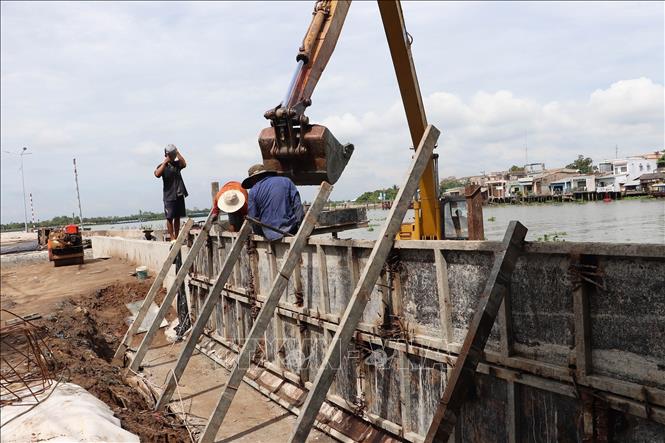 Công nhân khẩn trương hoàn thiện các hạng mục cuối cùng đoạn sạt lở bờ Đông sông Cái Bè dài 540m. Ảnh: Minh Trí - TTXVN