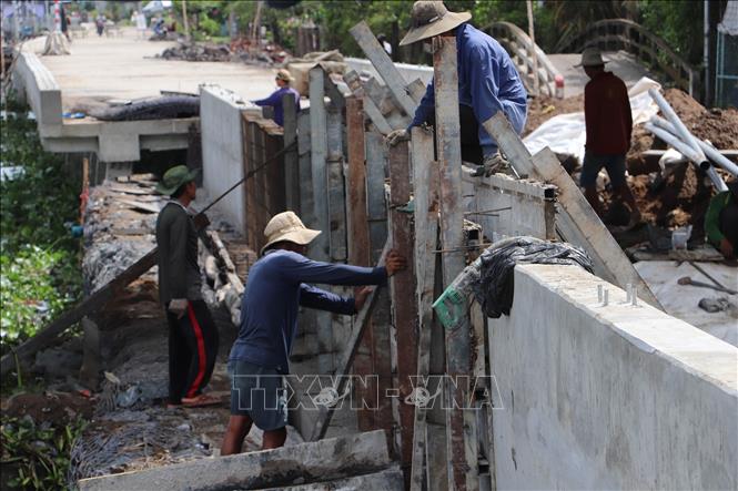 Công nhân khẩn trương hoàn thiện các hạng mục cuối cùng đoạn sạt lở bờ Đông sông Cái Bè dài 540m. Ảnh: Minh Trí - TTXVN