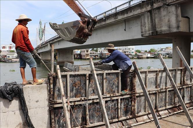 Công nhân khẩn trương hoàn thiện các hạng mục cuối cùng đoạn sạt lở bờ Đông sông Cái Bè dài 540m. Ảnh: Minh Trí - TTXVN