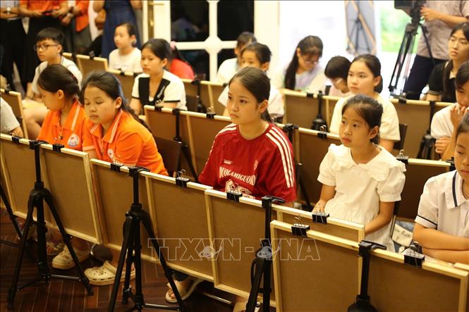 Các em nhỏ chăm chú trong buổi học đầu tiên được nghe các họa sĩ nổi tiếng chia sẻ các kiến thức về hội họa. Ảnh: Mạnh Minh - TTXVN 