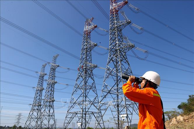 Công nhân đội truyền tải điện Bắc Bình (Bình Thuận) kiểm tra tuyến đường dây trên địa bàn huyện Tuy Phong. Ảnh: Huy Hùng - TTXVN