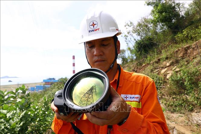 Công nhân đội truyền tải điện Nha Trang (Khánh Hòa) kiểm tra soi phát nhiệt trên tuyến đường dây 500kV Vân Phong-Thuận Nam. Ảnh: Huy Hùng - TTXVN