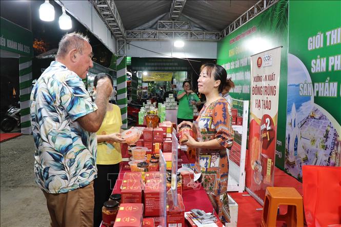 Du khách nước ngoài tham quan gian hàng đặc sản. Ảnh: Đặng Tuấn - TTXVN  