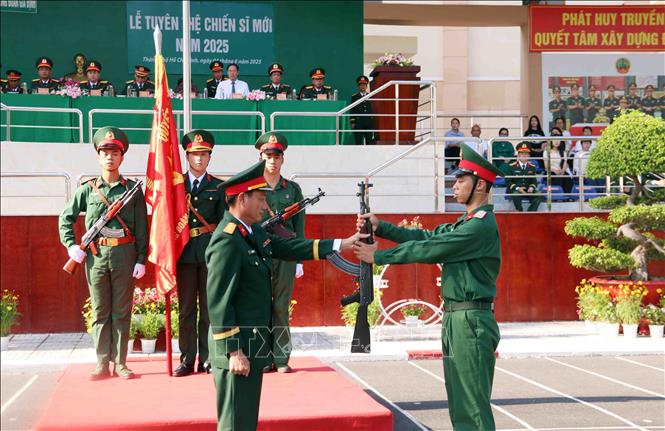 Thượng tá Võ Chí Tâm (trái), Trung đoàn trưởng Trung đoàn Gia Định, Bộ Tư lệnh Thành phố Hồ Chí Minh thực hiện nghi thức trao vũ khí cho chiến sĩ mới. Ảnh: Xuân Khu-TTXVN