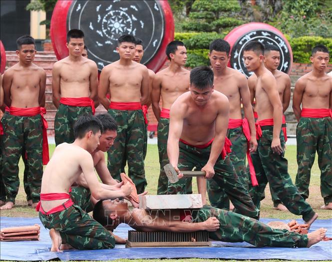 Biểu diễn công phá: đập đá trên người nằm trên bàn chông của chiến sĩ năm thứ 2. Ảnh: Trọng Đức - TTXVN