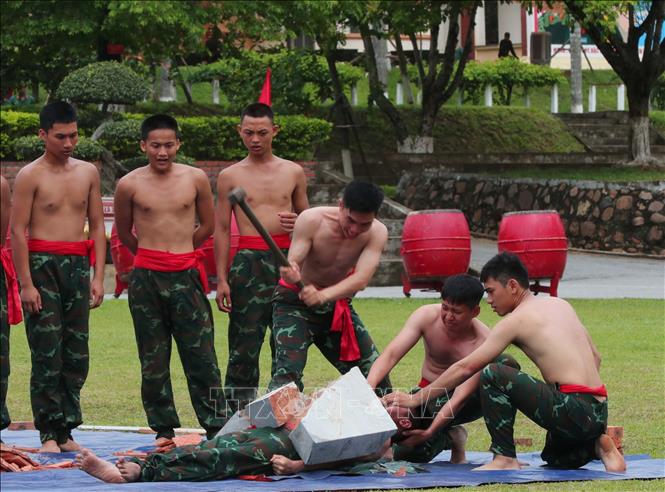Biểu diễn công phá: đập đá trên người nằm trên bàn chông của chiến sĩ năm thứ 2. Ảnh: Trọng Đức - TTXVN