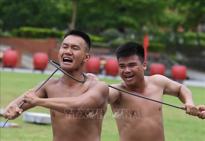 Biểu diễn công phá: cuốn thép quanh cổ. Ảnh: Trọng Đức - TTXVN

