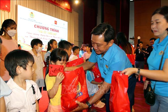 Ông Nguyễn Trọng Tín, Giám đốc Trung tâm công tác xã hội Công đoàn Thành phố Hồ Chí Minh trao quà cho các em thiếu nhi. Ảnh: Thanh Vũ-TTXVN