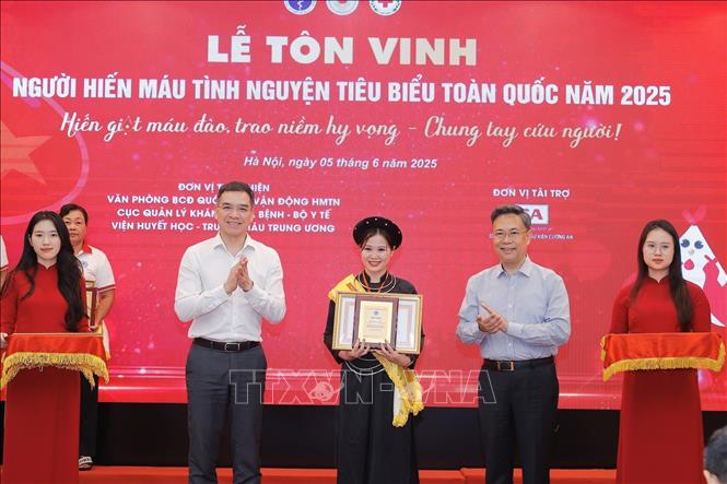 Ban tổ chức tôn vinh 100 đại biểu người hiến máu tiêu biểu năm 2025. Ảnh: Minh Quyết - TTXVN