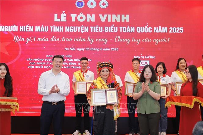 Ban tổ chức tôn vinh 100 đại biểu người hiến máu tiêu biểu năm 2025. Ảnh: Minh Quyết - TTXVN