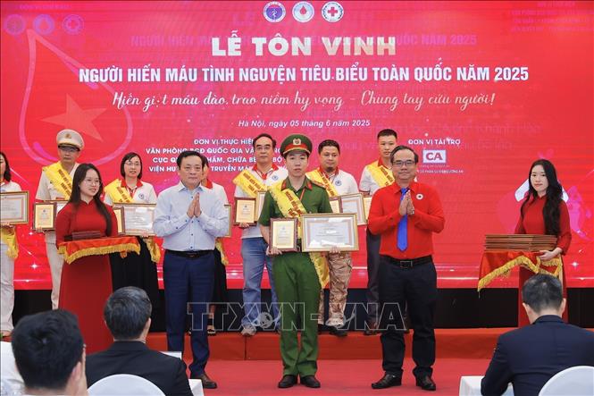 Ban tổ chức tôn vinh 100 đại biểu người hiến máu tiêu biểu năm 2025. Ảnh: Minh Quyết - TTXVN