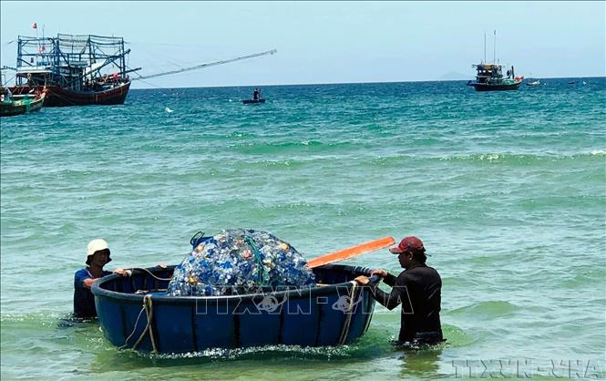 Ngư dân xã Bình Minh, huyện Thăng Bình, tỉnh Quảng Nam đưa rác thải biển vào bờ. Ảnh Trần Tĩnh – TTXVN