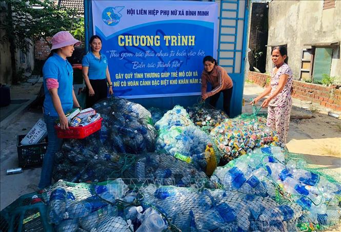 Nhóm phụ nữ xã Bình Minh, huyện Thăng Bình, tỉnh Quảng Nam chuyên thu gom túi lưới đựng vỏ lon, chai nước và các loại rác thải trên tàu đưa lên bờ rồi phân loại. Ảnh: Trần Tĩnh – TTXVN