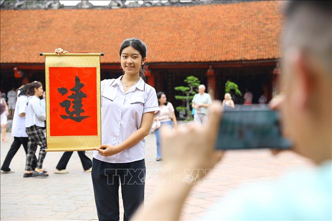 Phụ huynh và thí sinh đến Văn miếu - Quốc Tử Giám cầu may mắn và xin chữ “Đạt” trước kỳ tuyển sinh vào lớp 10. Ảnh: Lê Đông - TTXVN