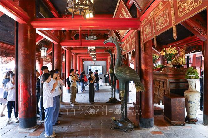 Thí sinh và người nhà dâng hương cầu may tại Văn miếu - Quốc Tử Giám. Ảnh: Lê Đông - TTXVN