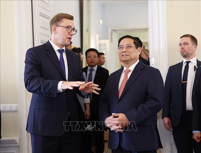 Thủ tướng Cộng hòa Estonia Kristen Michal giới thiệu với Thủ tướng Phạm Minh Chính Văn phòng làm việc của Chính phủ. Ảnh: Dương Giang-TTXVN 
